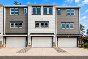 A three-story residential building with a garage on each level. - Modern Charlotte Retreat - Sleeps 10 - Near UNCC & Uptown (Charlotte)