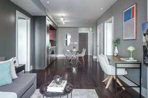 Ein modernes Wohnzimmer mit einer Couch, einem Couchtisch und einem Essbereich mit Stühlen.