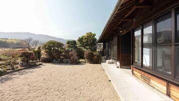 A traditional Japanese-style building with a gravel courtyard and a view of distant mountains.