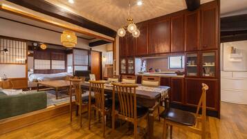 A traditional Japanese-style room with tatami flooring, a low table with chairs, and a sliding shoji screen door.