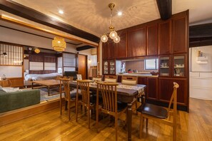 A traditional Japanese-style room with tatami flooring, a low table with chairs, and a sliding shoji screen door.
