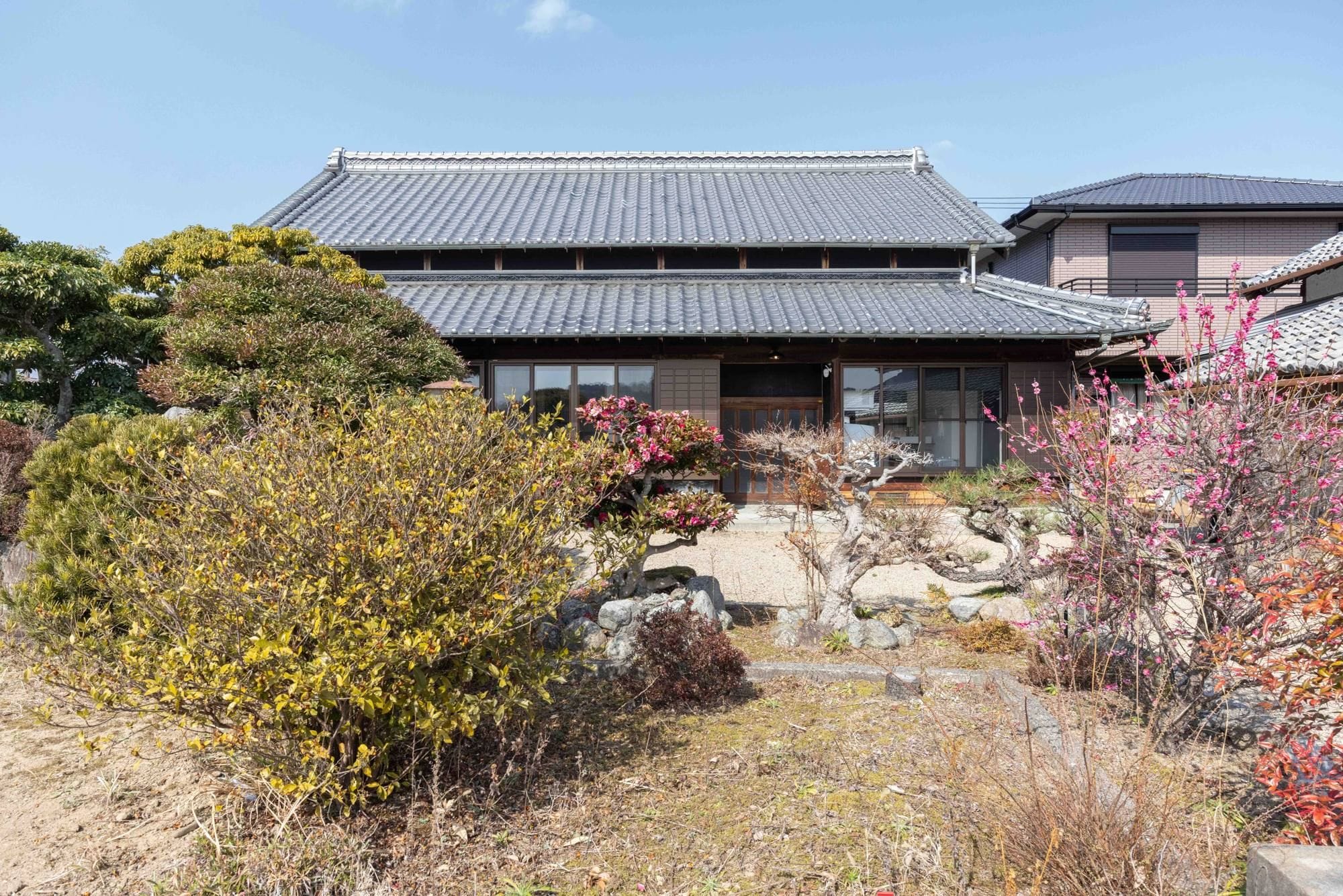 A traditional Japanese building with a tiled roof and a stone pathway leading to the entrance.