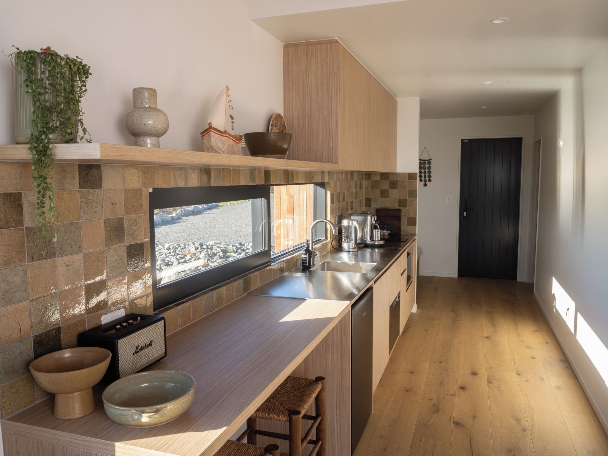 A modern kitchen with a large window, a built-in stove, and a wooden countertop.
