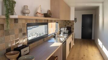A modern kitchen with a large window, a built-in stove, and a wooden countertop.