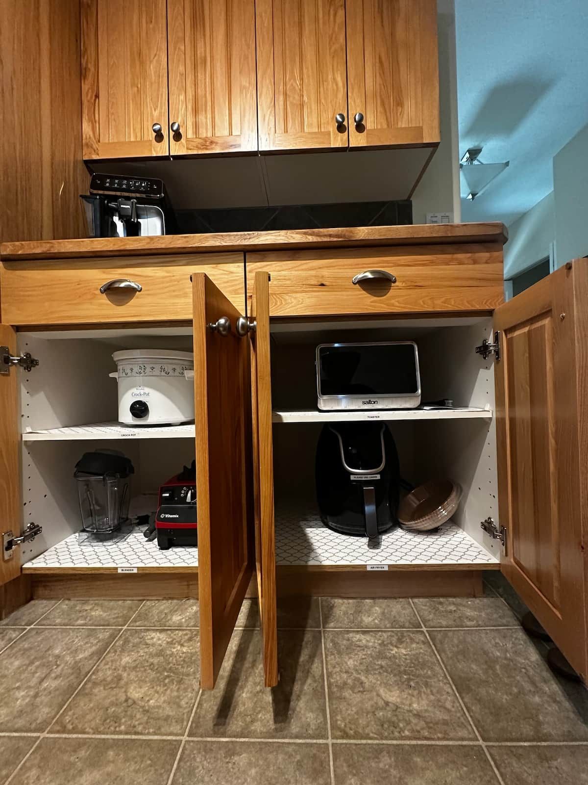 A kitchen with wooden cabinets, a toaster, a blender, and a crockpot.