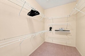 Un cuarto de lavandería con varios tendederos y un ventilador.