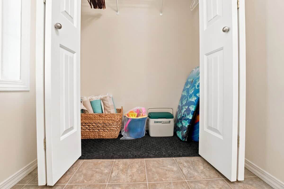 A hallway with a door, a wicker basket, a plastic storage bin, and a laundry basket.
