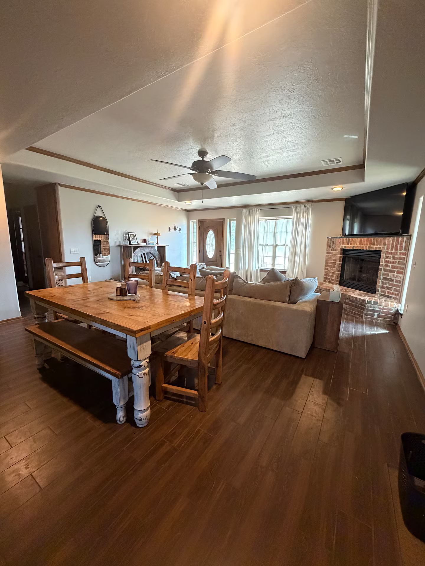Amplia sala de estar con una mesa de comedor de madera, un sofá y una chimenea.