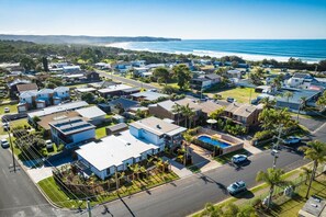 A coastal residential area with houses, a swimming pool, and a view of the ocean. - Wananavu | Tathra Escape (Tathra)