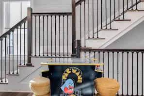 A staircase with a handrail and a landing area with a small table featuring a cartoon character. - Beach Access • Golf Cart • Sauna+ColdPlunge • Pool (Santa Rosa Beach)