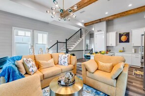 A modern living room with a sofa set, a coffee table, and a staircase leading to a kitchen. - Beach Access • Golf Cart • Sauna+ColdPlunge • Pool (Santa Rosa Beach)