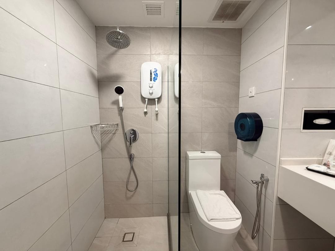 Une salle de bain moderne avec une douche à parois de verre, des toilettes et un lavabo.