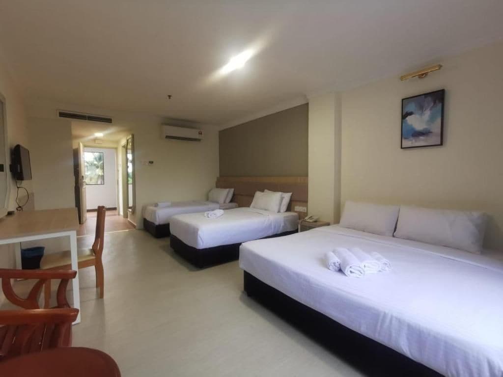 Una habitación de hotel con dos camas, un escritorio y una silla.