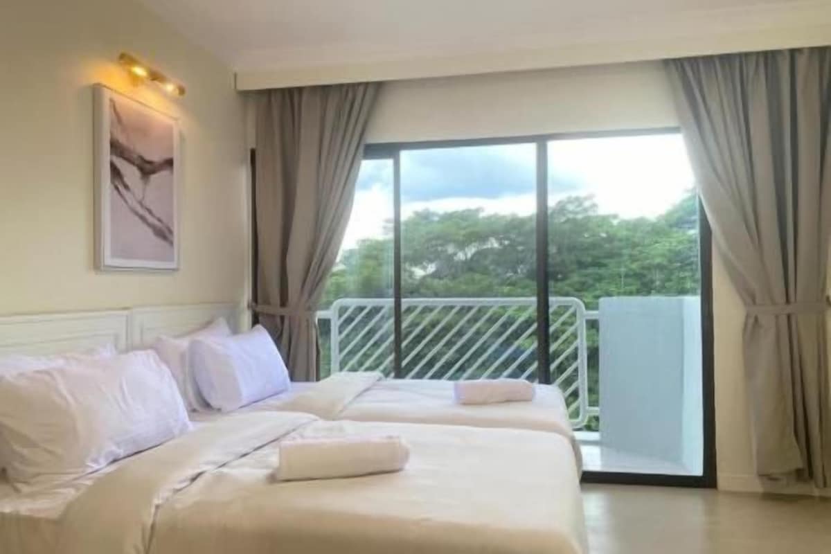 A hotel room with two beds, a large window, and a balcony.
