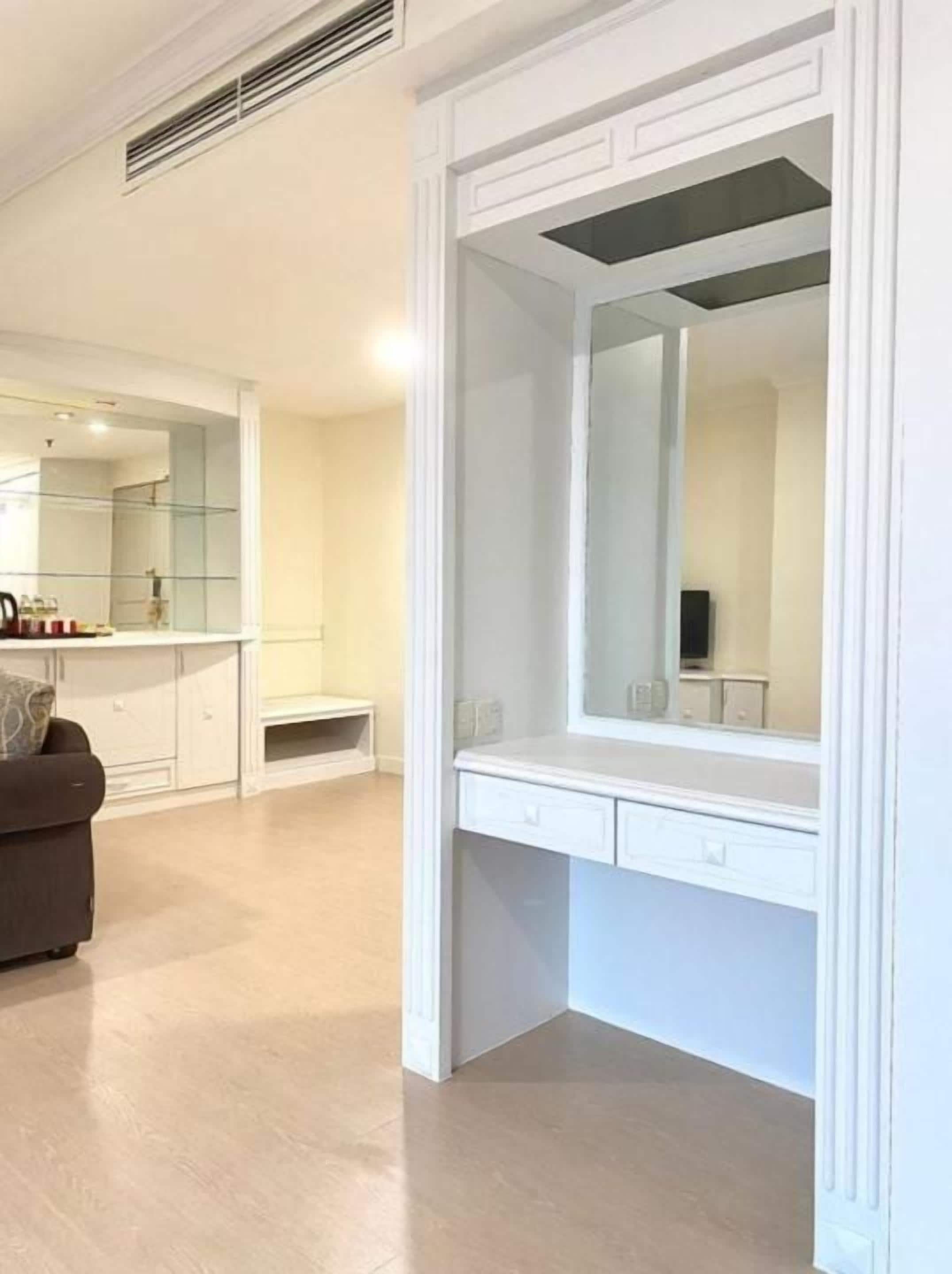 Un baño moderno con un espejo grande, tocador y zona de ducha.