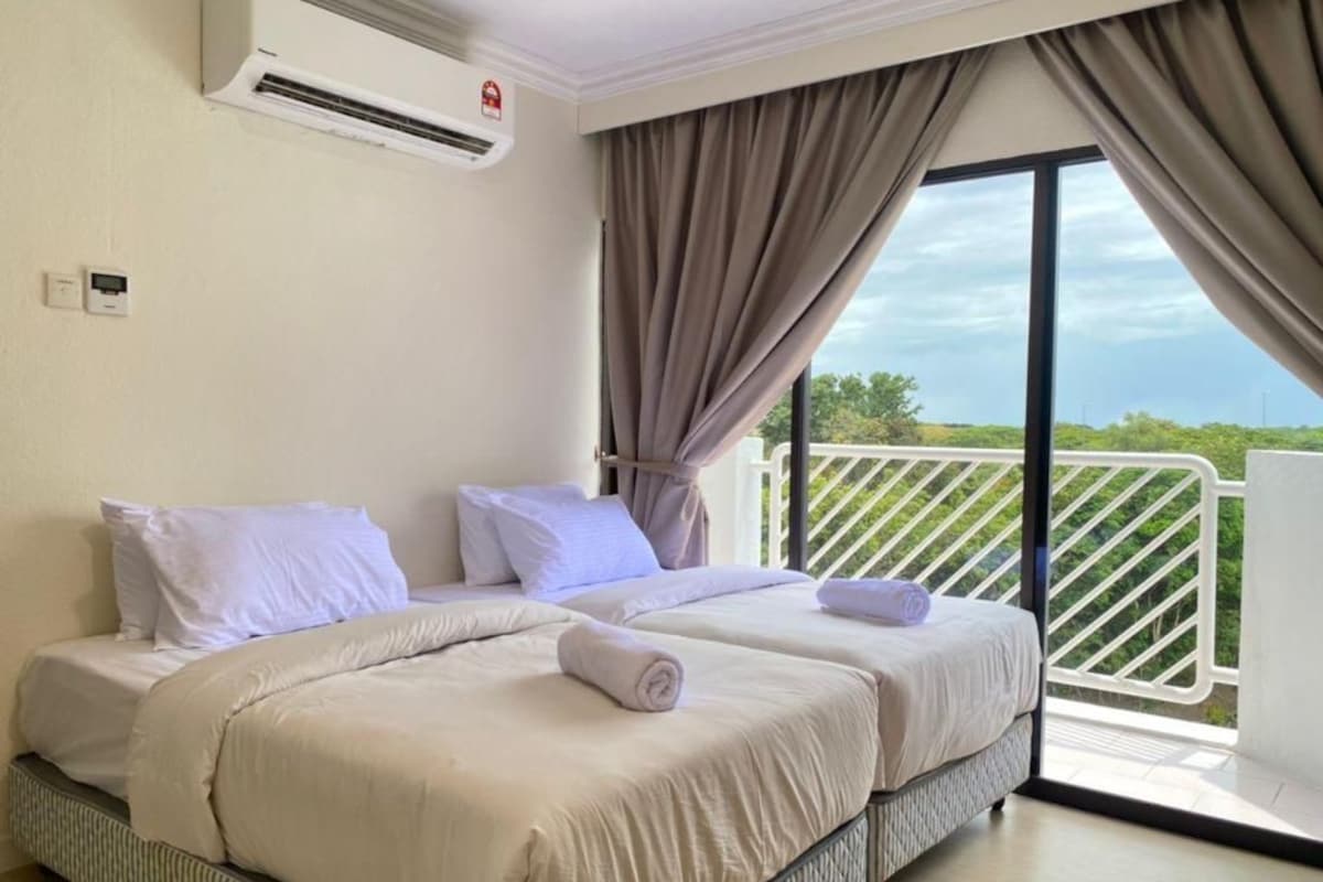 A hotel room with two beds, a balcony with a view, an air conditioning unit, and a window with curtains.