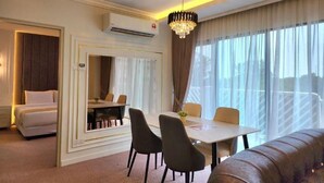 A hotel room with a bed, a dining area, a chandelier, and large windows. - SWISS AVENUE HOTEL SUNGAI PETANI  (Sungai Petani)