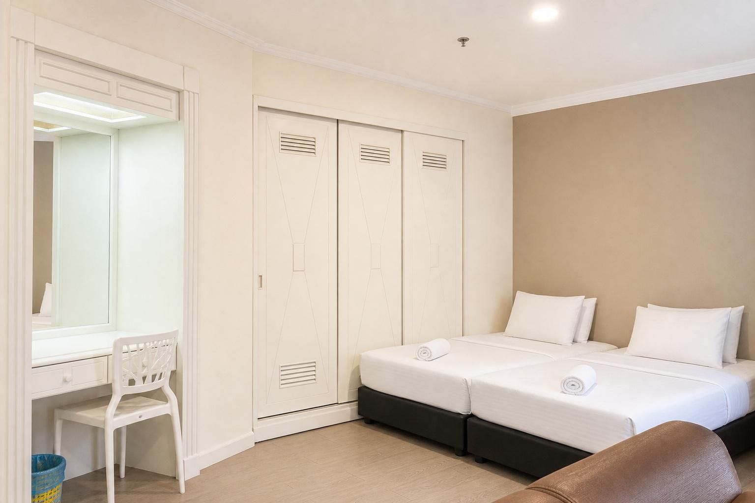 A bedroom with a double bed, a desk with a chair, and a wardrobe.