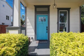 A house with a blue door, a small porch, and a window with blinds. - Craftsman Bungalow in D'heart of the Arts District (Houston)