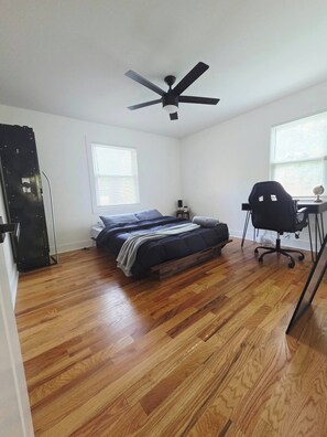 A bedroom with a bed, a desk, a chair, a ceiling fan, and a window. - Home away from home. Cozy. Comfortable. Clean (Atlanta)