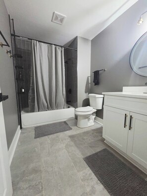 A modern bathroom with a shower, toilet, and vanity. - Home away from home. Cozy. Comfortable. Clean (Atlanta)