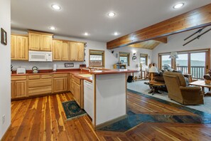 A spacious kitchen with wooden cabinets, a microwave, and a dishwasher. - Ski-In/Ski-Out Schweitzer Chalet w/ Hot Tub (Sandpoint)