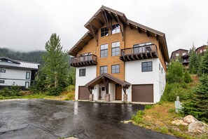 A multi-story wooden house with a sloped roof, a front porch, and a garage. - Ski-In/Ski-Out Schweitzer Chalet w/ Hot Tub (Sandpoint)
