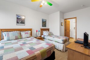 A bedroom with two beds, a desk, a television, and a ceiling fan. - Ski-In/Ski-Out Schweitzer Chalet w/ Hot Tub (Sandpoint)