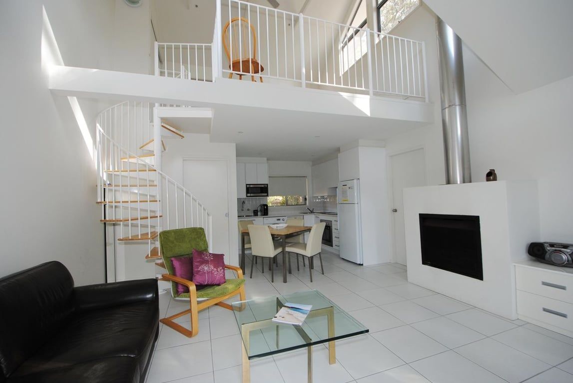 Um apartamento moderno com área de estar no estilo loft, espaço para refeições e cozinha.