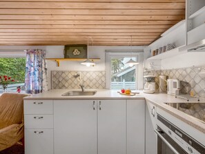 A compact kitchen with a wooden ceiling, a sink, a stove, and a window with a view of the outside. - "Kierulf" - 1km to the fjord by Interhome (Hemmet)