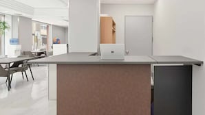A modern office space with a reception desk, a laptop, and a door in the background. - ATO Hotel Kyoto (Kyoto)