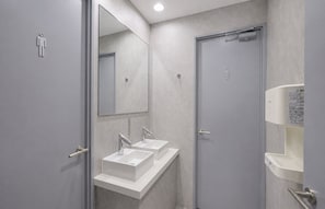 Une salle de bain moderne avec deux lavabos, un miroir et des toilettes.