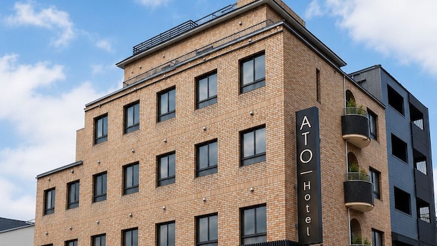 A multi-story hotel with a brick facade, large windows, and a sign indicating it's a hotel. - ATO Hotel Kyoto (Kyoto)