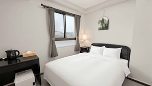 A hotel room with a bed, a desk, a kettle, a lamp, and a view of the city. - ATO Hotel Kyoto (Kyoto)