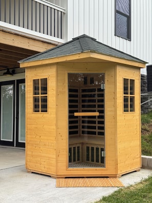 A wooden gazebo with a sloped roof, a glass door, and a wooden bench inside. - Cozy and fun modern cottage in Luray, VA. (Luray)