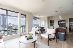 A modern apartment with a balcony, a dining area, and a kitchen. - Luxurious 2 bed 2 bath Corner Unit-City View #521 (Nashville)