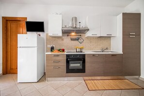 Et moderne køkken med indbygget ovn, mikroovn og køleskab.