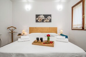 A neatly made bed with white linens, a tray of food, and a bouquet of flowers. - Casa Angela With Pool, Pittulongu, Italy (Pittulongu)