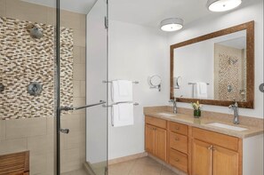 Une salle de bain moderne avec une douche à parois de verre, un meuble-lavabo en bois et un grand miroir.