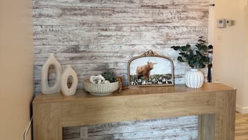Una consola de madera con objetos decorativos frente a una pared con textura.