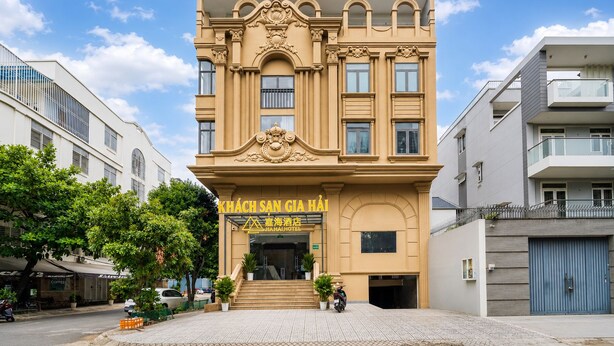 A hotel with a prominent entrance, a staircase leading to the entrance, and a clear sky. - Gia Hai Hotel  (Ho Chi Minh)