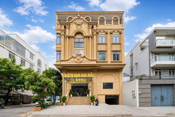A hotel with a prominent entrance, a staircase leading to the entrance, and a clear sky. - Gia Hai Hotel (Ho Chi Minh)