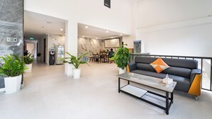 A modern lobby with a reception desk, seating area, and a water dispenser. - Gia Hai Hotel  (Ho Chi Minh)