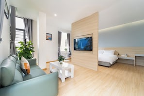 A modern hotel room with a sofa, a coffee table, a TV, and a bed. - Gia Hai Hotel (Ho Chi Minh)