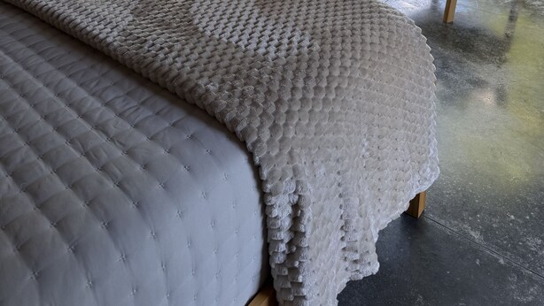 Un alloggio in tenda con un letto, due sedie, un tavolino e vista sul verde.