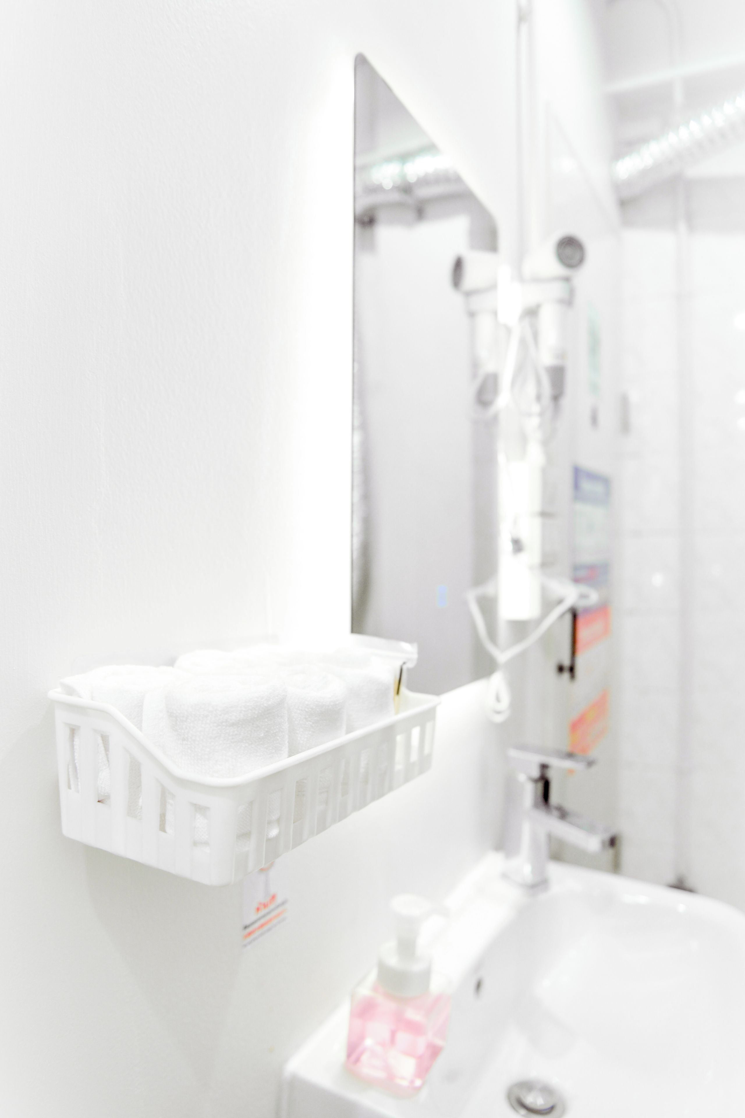 A bathroom with a white sink, a mirror, and a towel rack.