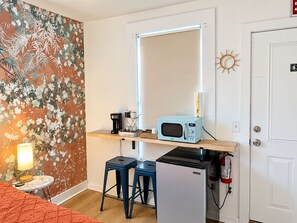 A compact kitchenette with a microwave, refrigerator, and bar stools. - Charming Stay Near Historic District St. Augustine (St. Augustine)
