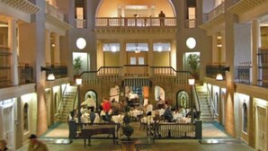 A multi-level atrium with a central staircase, multiple seating areas, and a balcony overlooking the space. - Walkable Stay Near Flagler College & Historic Site (St. Augustine)