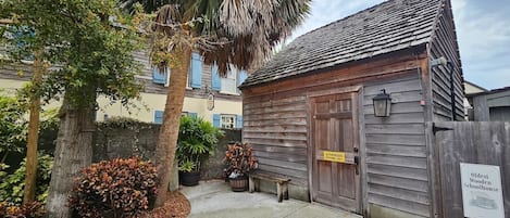 A wooden schoolhouse with a weathered exterior, a wooden door, and a sign indicating it is an authorized property.