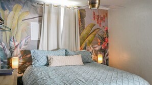 A bedroom with a bed, curtains, a ceiling fan, and a wall mural. - Walkable Stay Near Flagler College & Historic Site (St. Augustine)